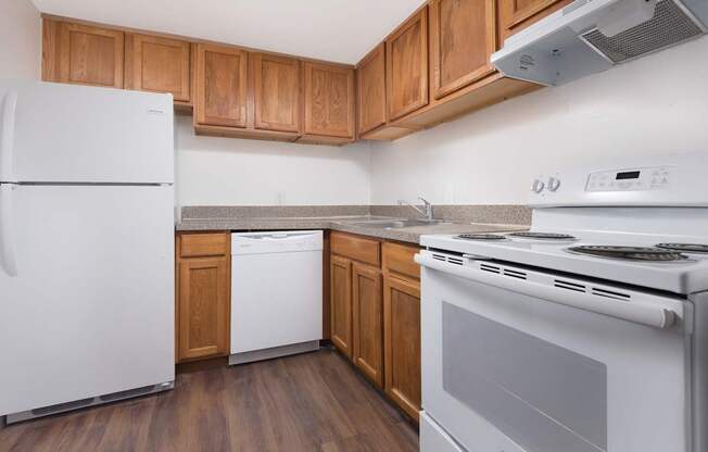 A white refrigerator is in a kitchen with wooden cabinets.