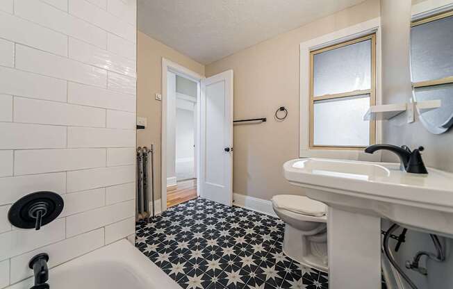 A white sink with a black faucet in a bathroom.