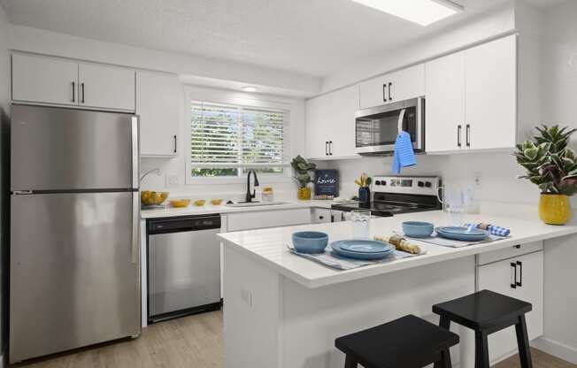 a kitchen with white cabinets and stainless steel appliances