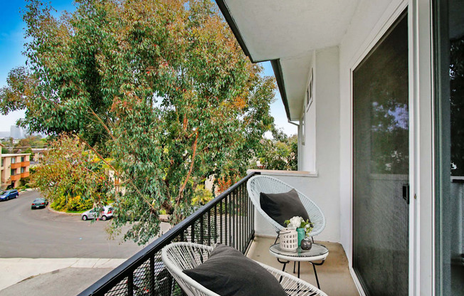 a balcony with two chairs and a table