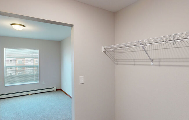 an empty bedroom with a closet and a window