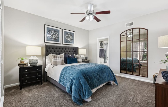 A bedroom with a bed, dresser, and mirror.