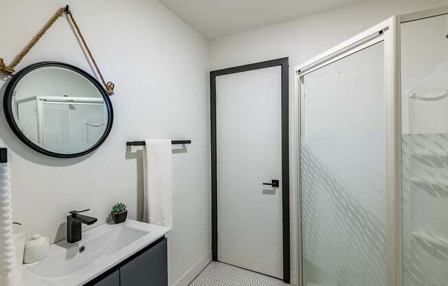 A bathroom with a white sink and a mirror above it.