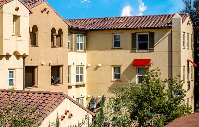 an apartment building with a red door and a blue sky