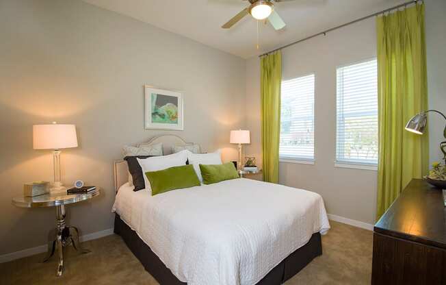 a bedroom with a white bed and green curtains