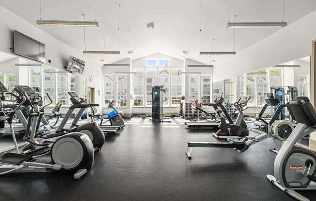 a gym with cardio equipment and weights on the floor