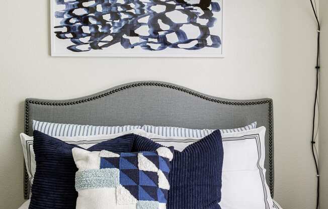 a bedroom with a large lamp and a bed with blue and white pillows