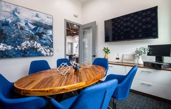 Conference room at stadium 700 apartments with large flat screen tv, oval conference table, and storage furniture