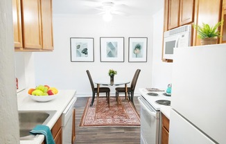 A kitchen with a table and chairs in the middle.