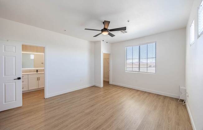 A room with a ceiling fan and wooden flooring.