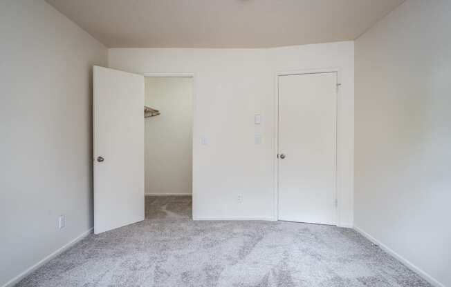 a bedroom with white walls and carpet