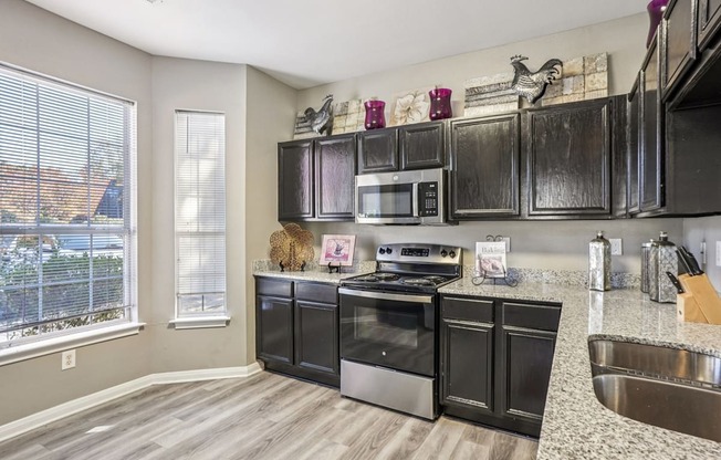 A kitchen with black cabinets and stainless steel appliances.