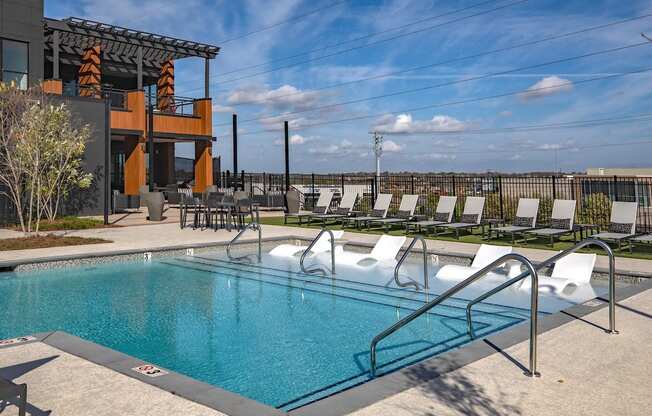 a swimming pool with lounge chairs at a hotel
