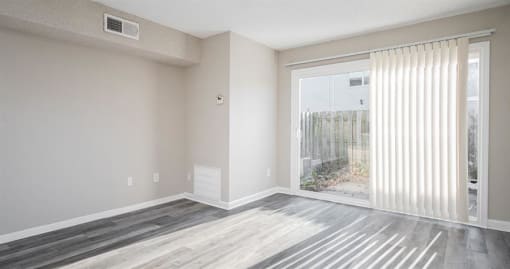 an empty living room with a sliding glass door