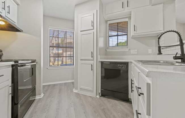 an empty kitchen with white cabinets and stainless steel appliances