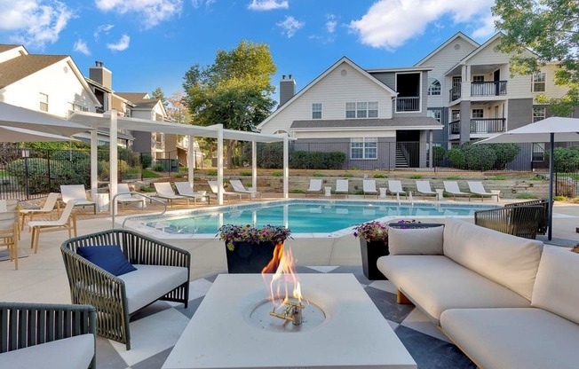 A poolside area with a lit candle on a table.