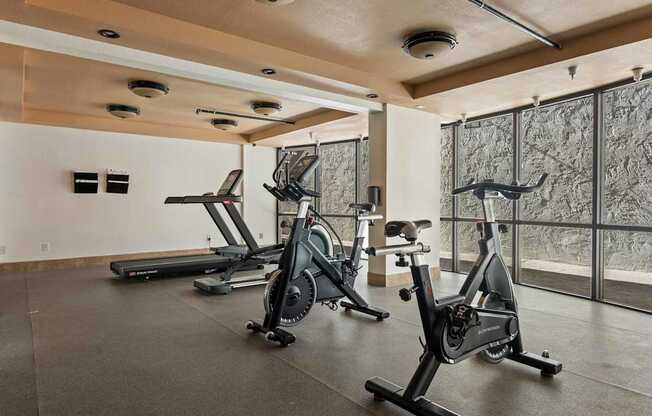 Three exercise bikes are lined up in a room.