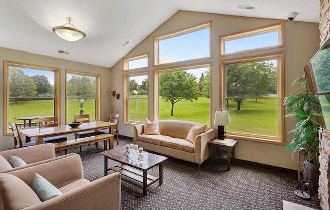 A living room with a large window overlooking a green field.