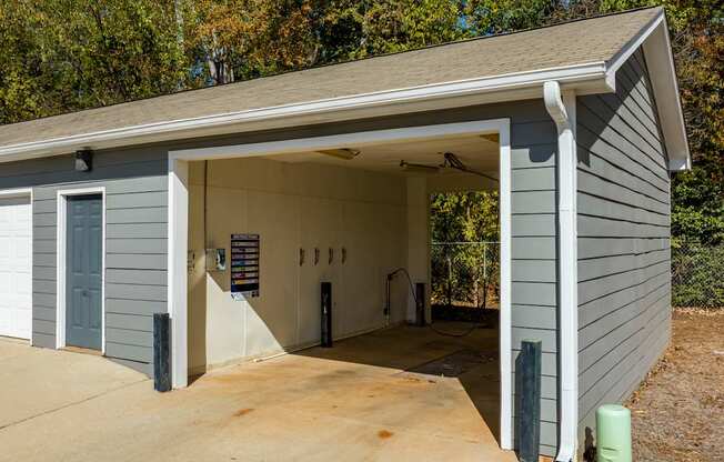 A garage with a grey siding and a white door is shown.