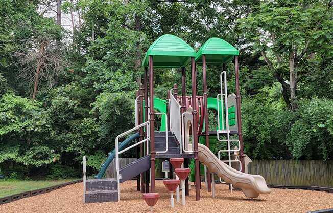 a playground with a set of slides in a park
