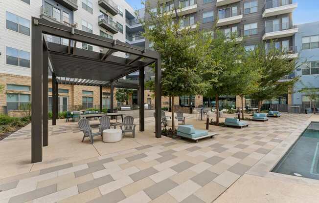 A patio with a table and chairs and a pool.