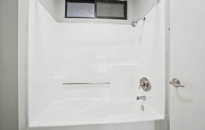 A white bathroom with a shower and a bathtub.