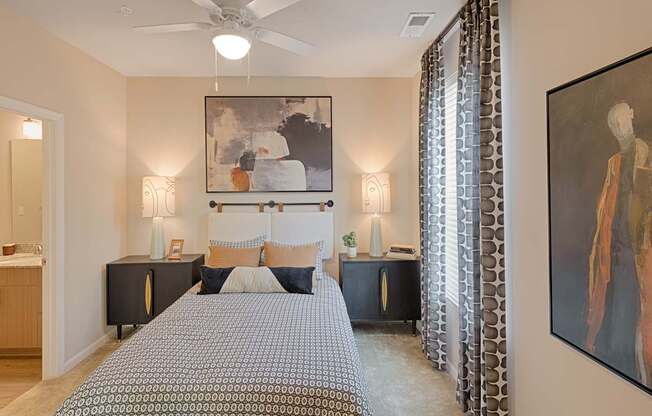 A bedroom with a large bed and a painting on the wall.
