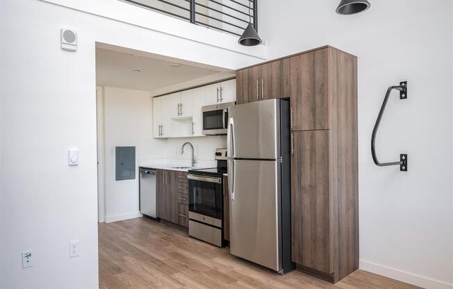 a kitchen with a stainless steel refrigerator and a wooden cabinet