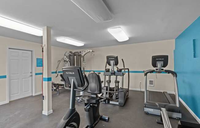 a gym with treadmills and other exercise equipment at the enclave at university heights