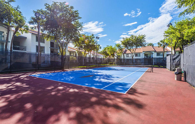 A tennis court with a blue surface and red court lines.