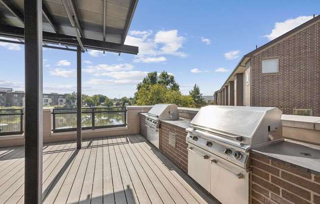 A patio with a grill and a table.