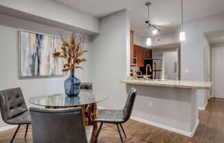 A dining room with a glass table and chairs.