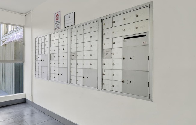 A wall of metal lockers with a warning sign above them.