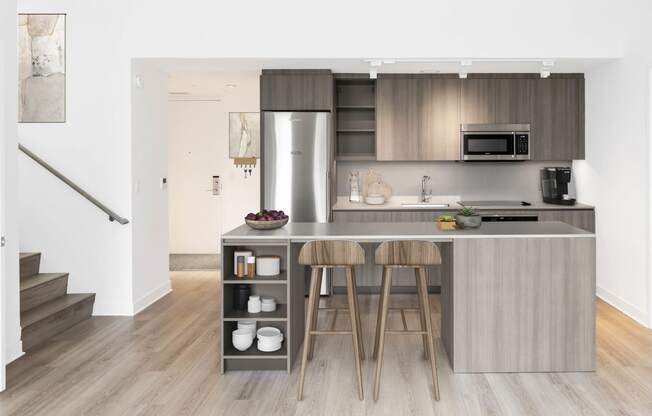 a kitchen with a large island with two stools in front of it