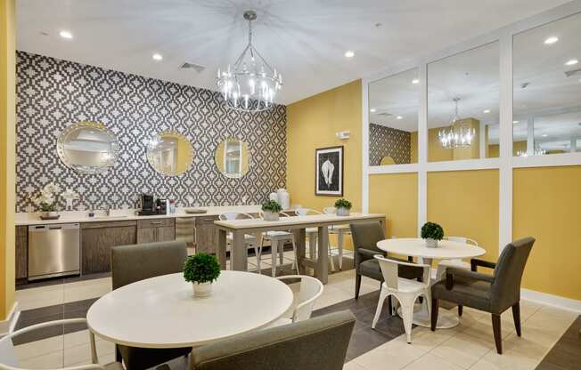 a dining room with tables and chairs and a kitchen