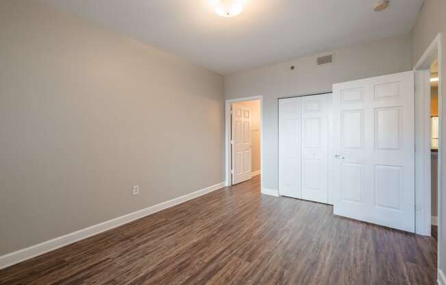 an empty living room with wood flooring and white doors at Crogman School Lofts, Atlanta, GA