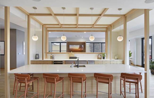 A kitchen with a white counter and brown stools.