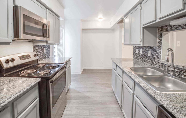 A kitchen with a stove top oven and a microwave.