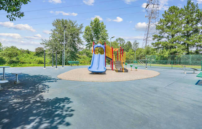 A playground with a blue slide and a red and yellow slide.