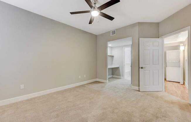 A room with a ceiling fan and carpeted floor.