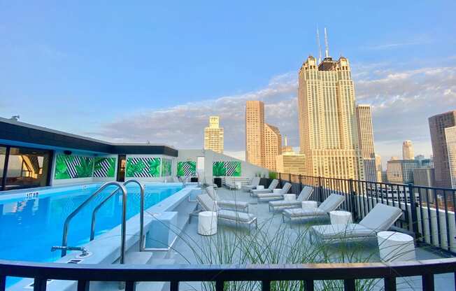 a pool on the roof of a building with a city in the background