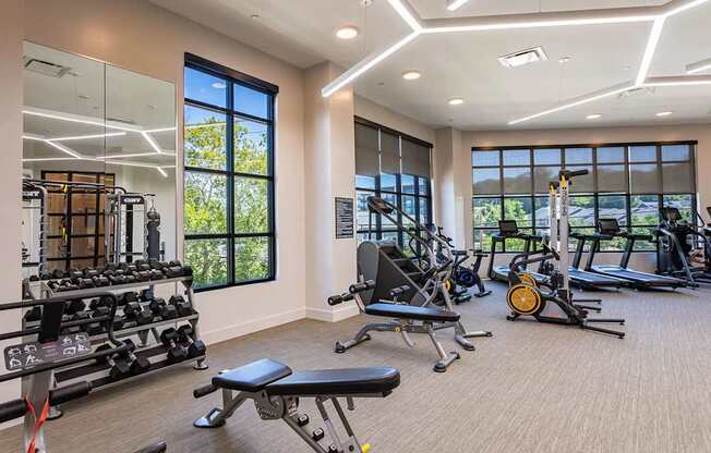 a gym with weights and other exercise equipment and windows