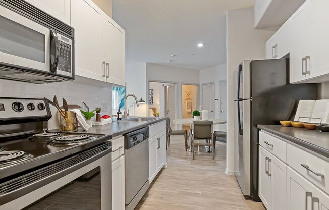 a kitchen with stainless steel appliances and white cabinets at Element Deer Valley, Phoenix, AZ