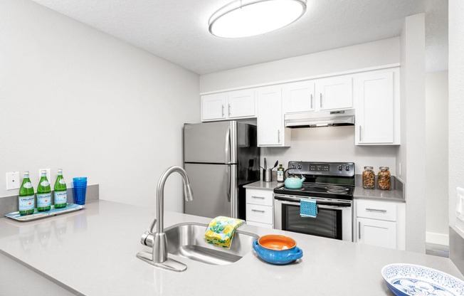a kitchen with white cabinetry and stainless steel appliances