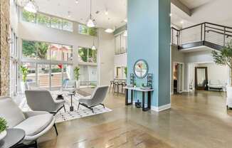 A spacious waiting area with grey chairs and a wooden floor.