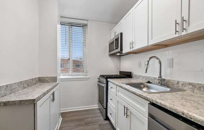 A kitchen with white cabinets and a granite countertop.