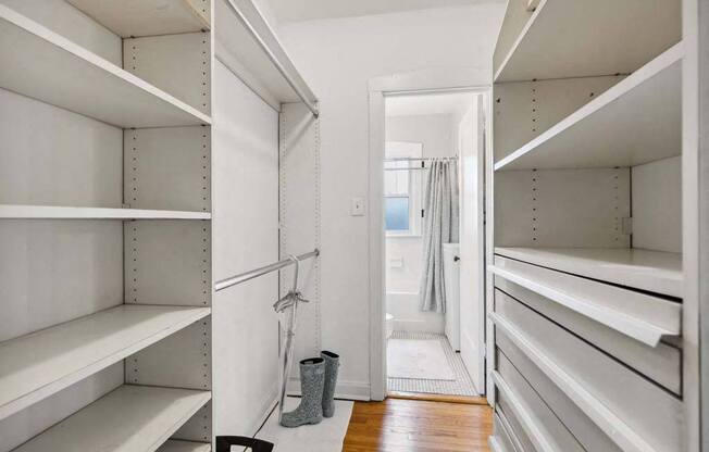 a large walk in closet with white shelves and a door at The Bryant at Oak Park I & II, Oak Park, 60302