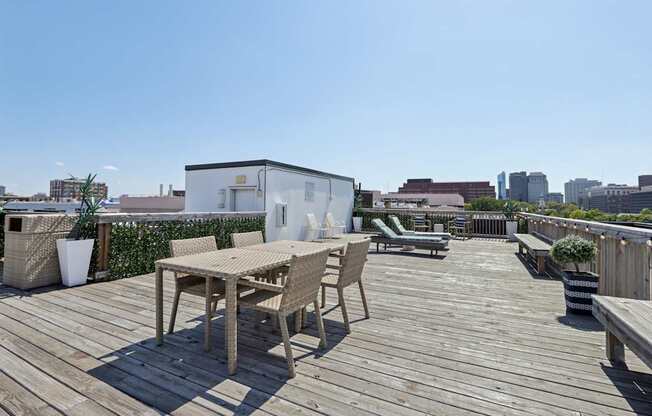 A wooden table and chairs are set up on a wooden deck.