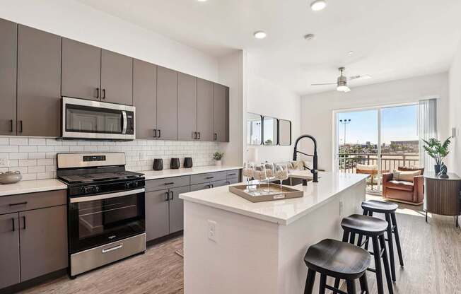 A modern kitchen with a white island and stainless steel appliances.