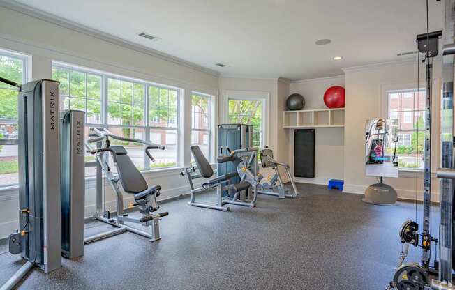 A gym with a variety of equipment including treadmills, weights, and exercise machines.